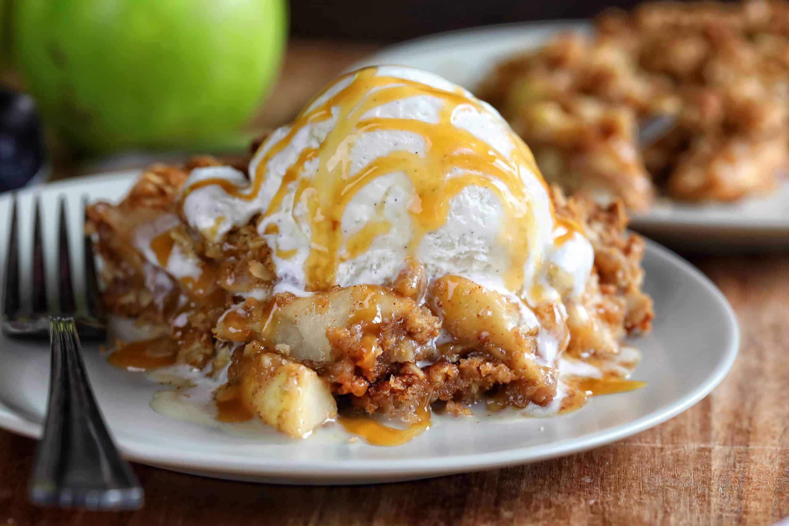 This is the only Apple Crisp recipe you will ever need!! HUGE flavor! Apple Crisp, Apple Crumble, perfect apple crisp, how to make apple crisp, easy apple crisp, i am baker, best apple crisp, easy apple crisp, award wining apple crisp, i am baker, iambaker, apple crumble recipe The Best Apple Crisp on Plate with Fork and Ice Cream.