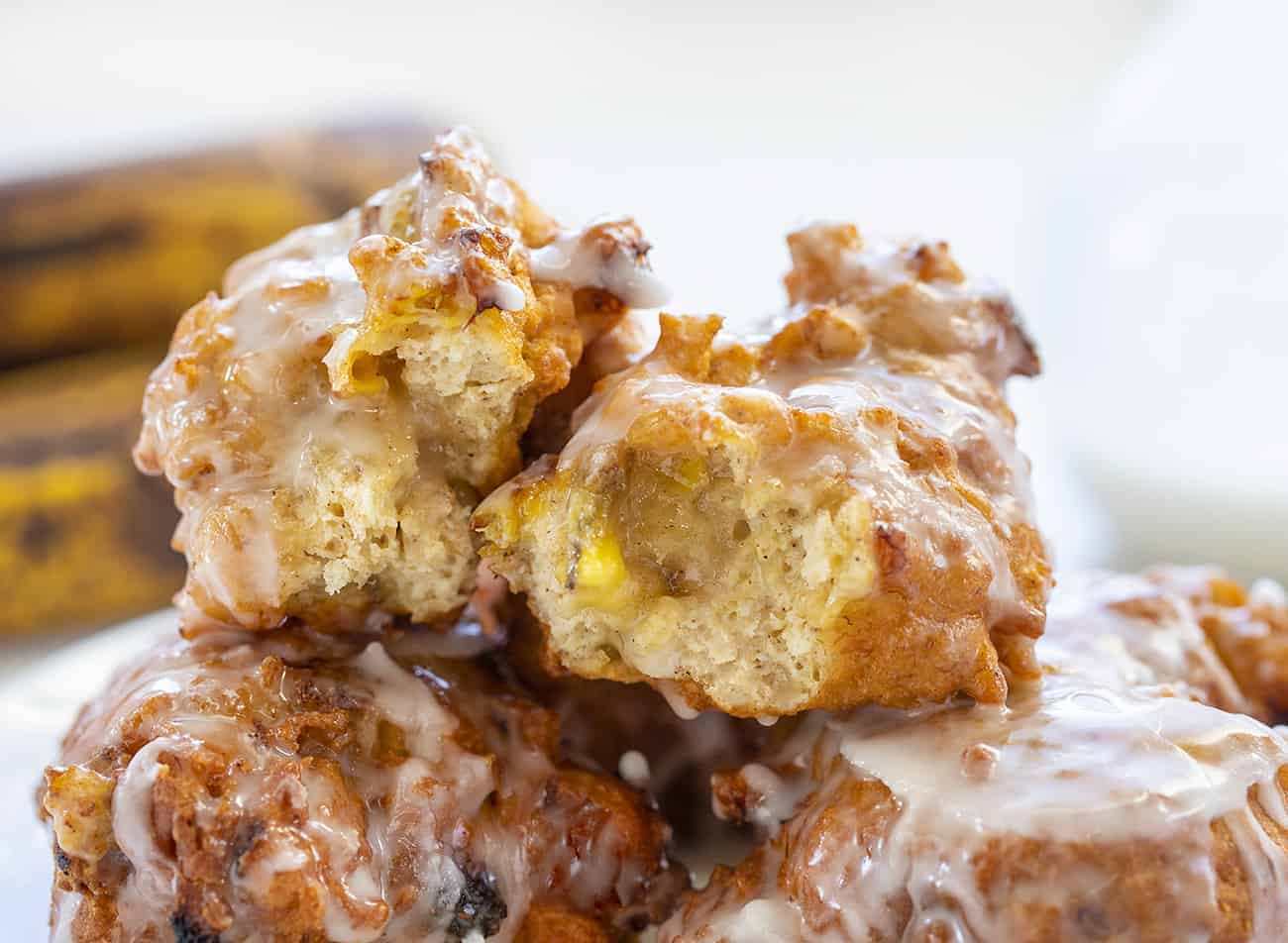 Banana Fritters are made with cakey batter, fried to perfection and loaded with bananas, all topped off with a sweet glaze. banana fritters, homemade fritters, fritters recipes, i am baker, iambaker, homemade glaze Open Banana Fritters Stacked