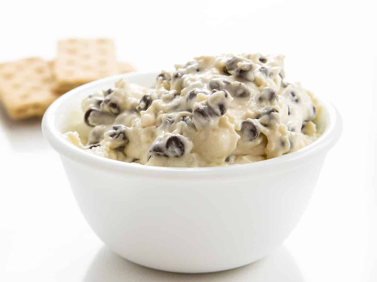 This cream cheese, no-bake Chocolate Chip Dip is a creamy and sweet dip that is as easy to whip together as it is to eat with your favorite sweet crackers or fruit! I saw it on TikTok and it was referred to as "Booty Dip". TikTok Booty Dip, Booty Dip, Dessert Dip, Easy Dip, Sweet Dip Recipes, Dessert, Cream Cheese Dip, Marshmallow Fluff Dip, Chocolate Chip Dip, i am baker, iambaker, recipes, tiktok Chocolate Chip Dip - TikTok Booty Dip Recipe in a White Bowl with Graham Crackers in Back
