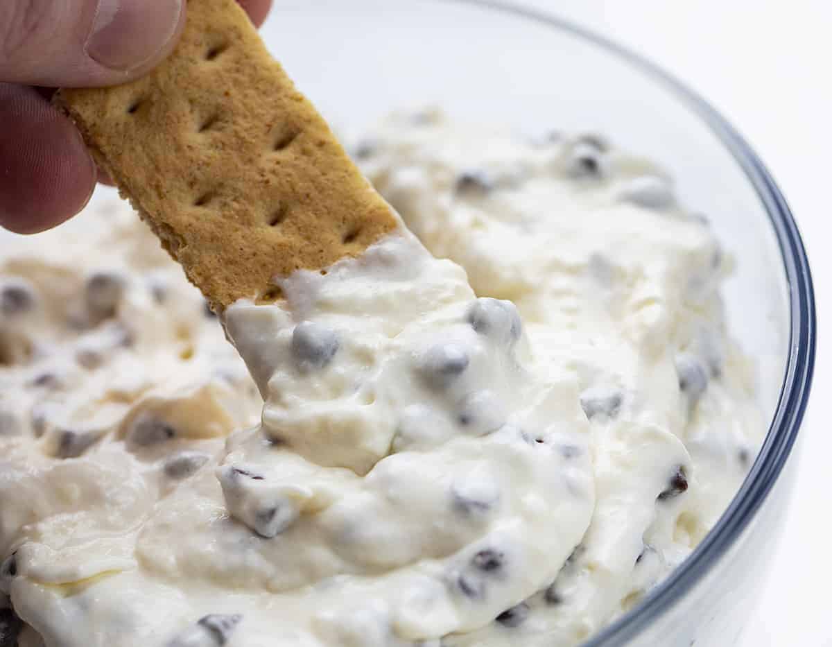 This cream cheese, no-bake Chocolate Chip Dip is a creamy and sweet dip that is as easy to whip together as it is to eat with your favorite sweet crackers or fruit! I saw it on TikTok and it was referred to as "Booty Dip". TikTok Booty Dip, Booty Dip, Dessert Dip, Easy Dip, Sweet Dip Recipes, Dessert, Cream Cheese Dip, Marshmallow Fluff Dip, Chocolate Chip Dip, i am baker, iambaker, recipes, tiktok Dipping a Graham Cracker into Chocolate Chip Dip - TikTok Booty Dip Recipe