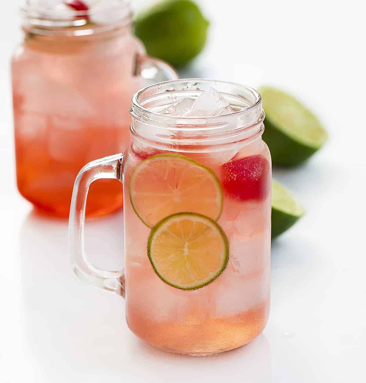 Cherry Limeade is a cold, refreshing non-alcoholic drink that is made with fresh lime juice, Sprite, and maraschino cherries, all poured over crushed ice! Cherry Limeade, Beverages, Non-Alcoholic Cocktails, Drinks, Drink Recipes, BBQ, How to Make Cherry Limeade, Sonic Copycat Limeade, Cherry Drinks, i am baker, iambaker, drink recipes Two Glasses of Cherry Limeade Drink with Fresh Lime