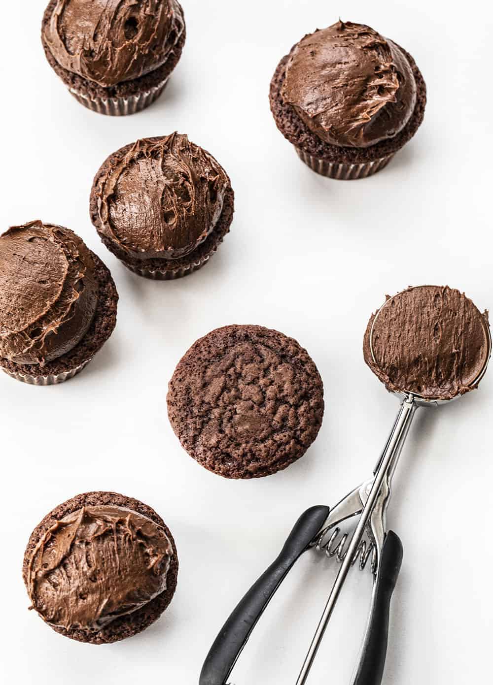 Chocolate Brownie Cupcakes are delectable chocolate cupcakes with a fine crumb and smooth texture, topped with homemade chocolate brownie frosting. chocolate brownie cupcake, chocolate cupcakes, brownie cupcakes, cupcakes recipes, homemade frosting, chocolate frosting, brownie frosting, iambaker, i am baker, baking, cupcakes Adding Chocolate Frosting to Chocolate Brownie Cupcakes from Overhead