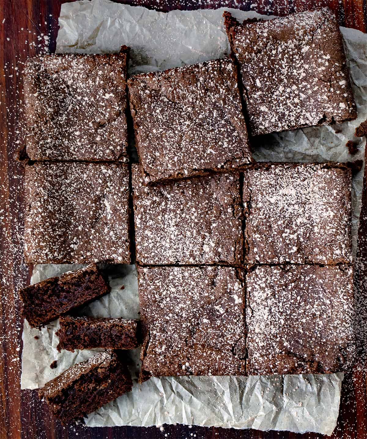 Crazy Brownies are moist brownies that are crazy good and just as crazy to make since they are made with NO milk, eggs, or butter! No frosting is needed, but you could sprinkle some confectioners sugar, or walnuts on top for a little bit of sweet crunch in each chocolatey bite. They are based on my Depression Cake, also known as Crazy Cake or Wacky Cake! Chocolate Brownies Cut into Squares and One cut Into Pieces Showing Inside.