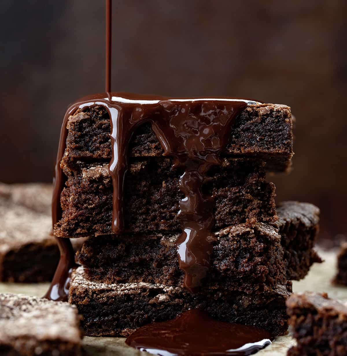Crazy Brownies are moist brownies that are crazy good and just as crazy to make since they are made with NO milk, eggs, or butter! No frosting is needed, but you could sprinkle some confectioners sugar, or walnuts on top for a little bit of sweet crunch in each chocolatey bite. They are based on my Depression Cake, also known as Crazy Cake or Wacky Cake! Chocolate Brownies Stacked on Top of Each other with Ganache Being drizzled on It.