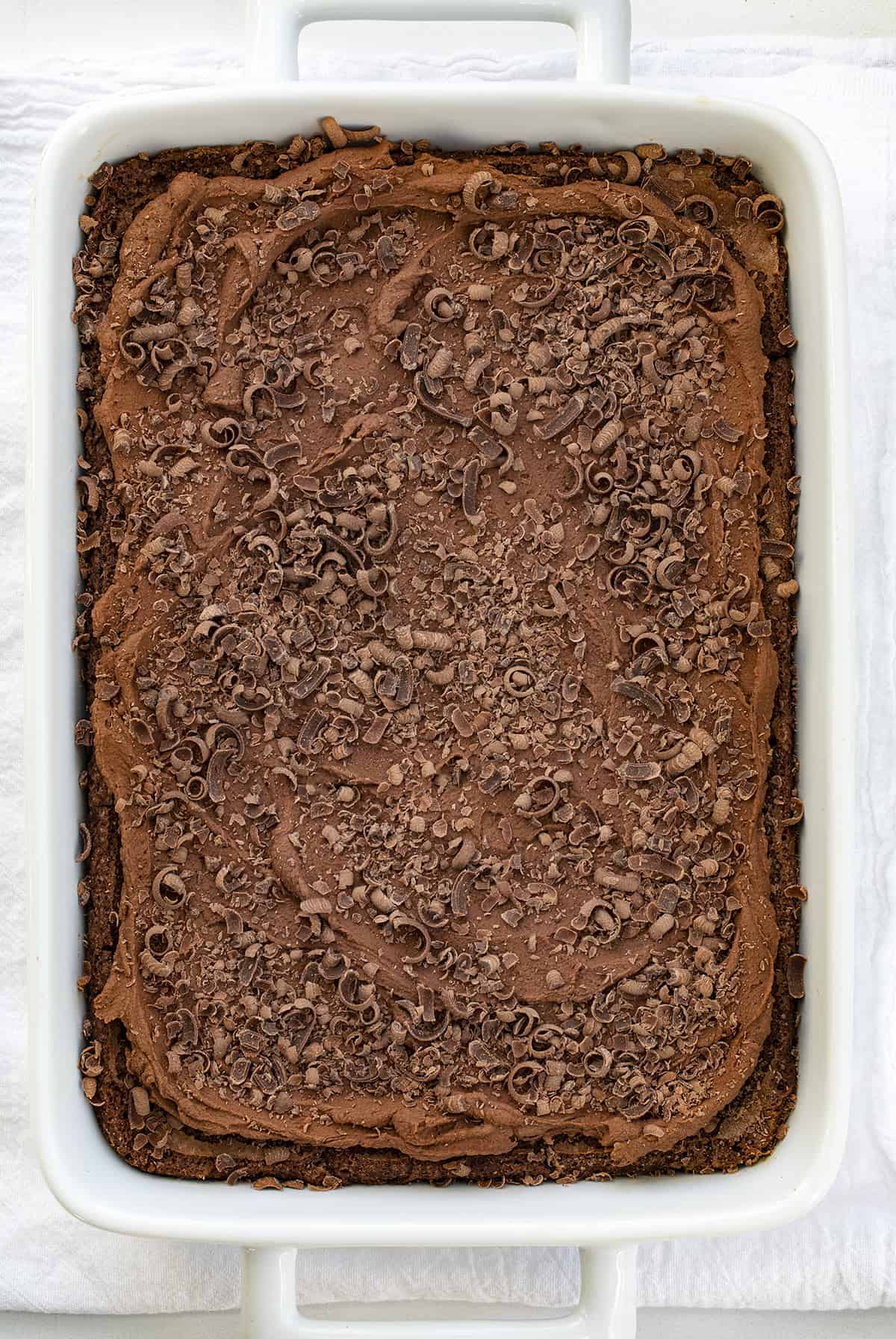 Chocolate Mousse Brownies are homemade brownies baked and topped with creamy chocolate mousse and chocolate curls. Brownies, Brownie Recipe, Chocolate Brownie Recipe, Chocolate Mousse Brownies, How to Make Mousse, Chocolate Mousse, Fudgy Brownies, Chocolate Brownies, Dessert, i am baker, iambaker Overhead of Chocolate Mousse Brownies in White Pan