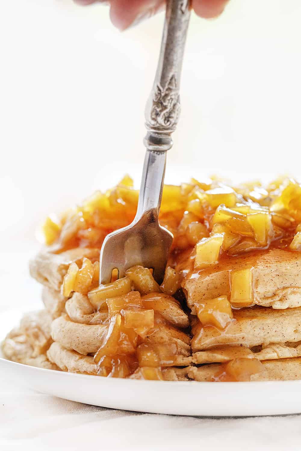 Light and fluffy apple pancakes topped with an apple topping make these Spiced Apple Pancakes too good to pass up! spiced apple pancakes, homemade apple pie spice, apple pie spice, apple spice, iambaker, comfort food, hot breakfast, pancakes, johnnycakes, hotcakes, breakfast, weekend breakfast Forkful of Spiced Apple Pancakes