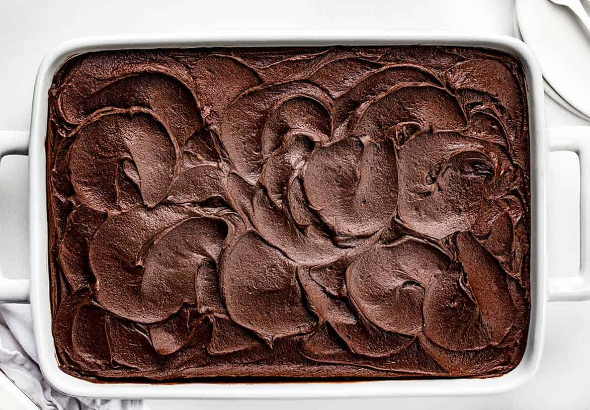 Chocolate Sauerkraut Cake is a soft and moist chocolate cake topped with a thick and creamy chocolate frosting. Chocolate Cake, Sauerkraut Cake, Chocolate Sauerkraut Cake, Vintage Cake, Old Fashioned Cake, Grandma's Chocolate Cake, Baking, Dessert, Chocolate Frosting, recipes, i am baker, iambaker Overhead of a Pan of Chocolate Sauerkraut Cake with Chocolate Swirled Frosting.