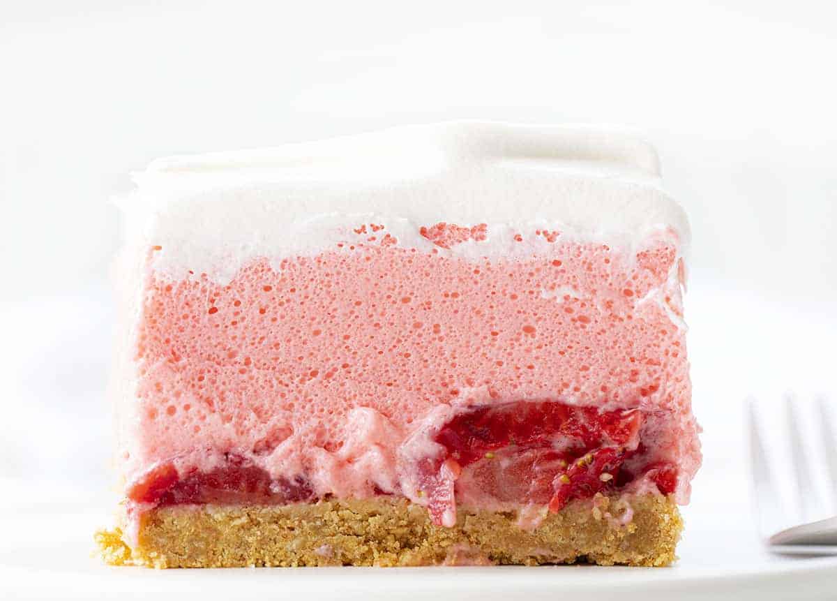 Strawberry Icebox Cheesecake is a light and fluffy no-bake dessert with fresh strawberries and a graham cracker crust. Strawberry Jello Cake, Woolworth Cake, Icebox Cake, Strawberry Woolworth Icebox Cake, Summer Cake, Refrigerator Cake, No Bake, Dessert, Strawberry Dessert, recipes, i am baker, iambaker Piece of Strawberry Icebox Cheesecake on a Plate with Fork